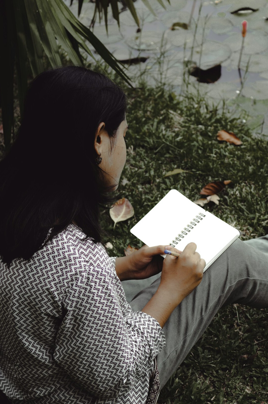woman writing in journal outdoors