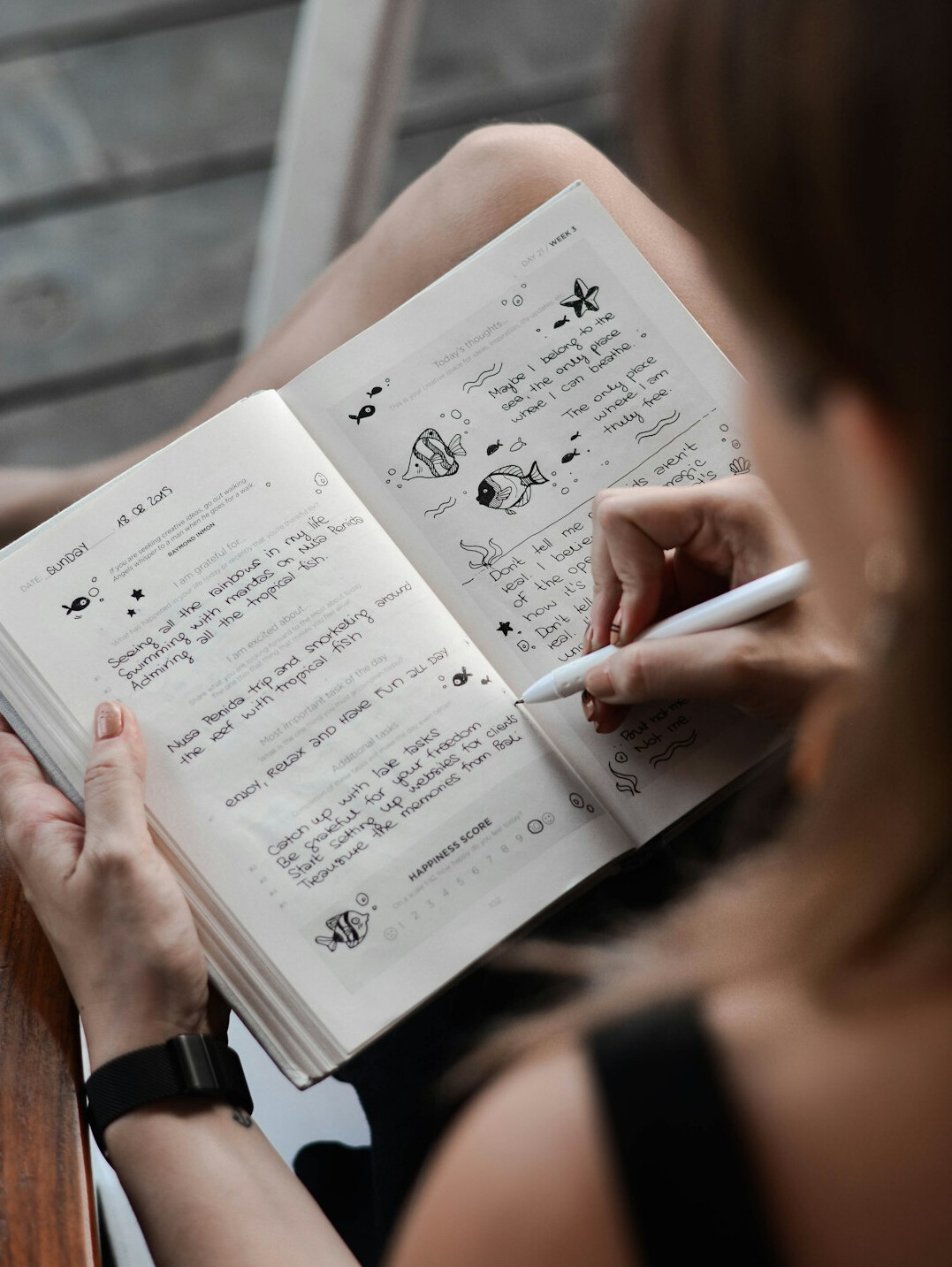 person writing goals in notebook